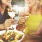 Friends sitting around a table eating and laughing	